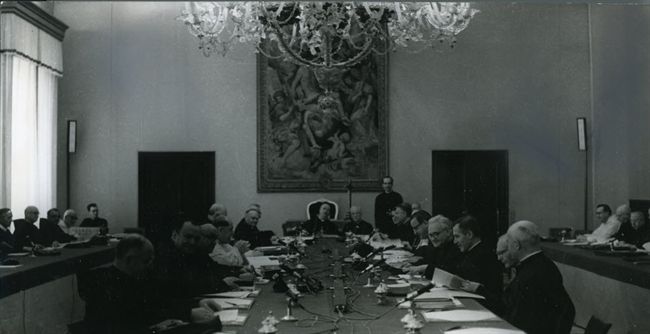 Vergadering van de belangrijke Voorbereidende theologische commissie met voorzitter kardinaal Ottaviani (midden) en rechts van hem secretaris Tromp